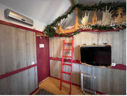 Una escalera roja en una habitación con TV en La Godille en Andon