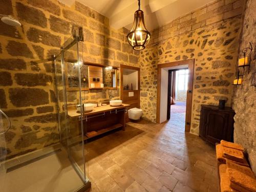 La salle de bains est pourvue d'une douche en verre et d'un lavabo. dans l'établissement Commanderie Templière de Cazouls d'Hérault, à Cazouls-d Herault