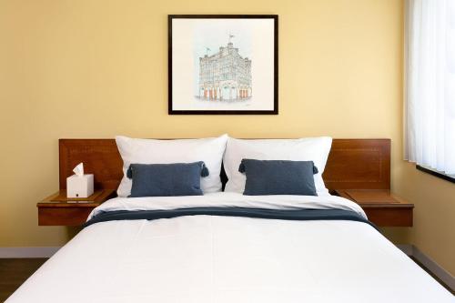 a bedroom with a white bed with blue pillows at Hotel Regina -Garni Köln in Cologne