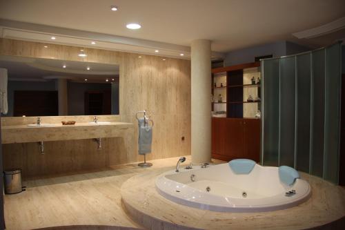 La grande salle de bains est pourvue d'une baignoire et de deux lavabos. dans l'établissement Hotel Alameda, à Alba de Tormes