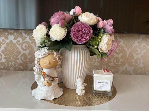 a vase with a bouquet of flowers on a table at Antakalnis 5 stars apartment in Vilnius