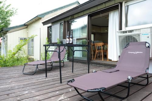 un patio con 2 sillas y una mesa en una terraza en Stay in Yamabe en Furano