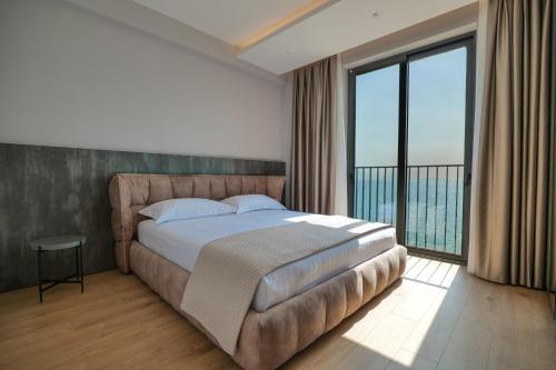 a bedroom with a large bed and a large window at DAED Luxury Residence in Sarandë