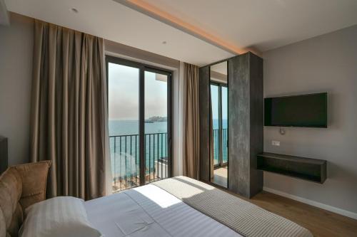 um quarto de hotel com uma cama e uma grande janela em Luxury Residence em Saranda