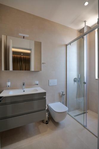 a bathroom with a sink and a toilet and a shower at DAED Luxury Residence in Sarandë