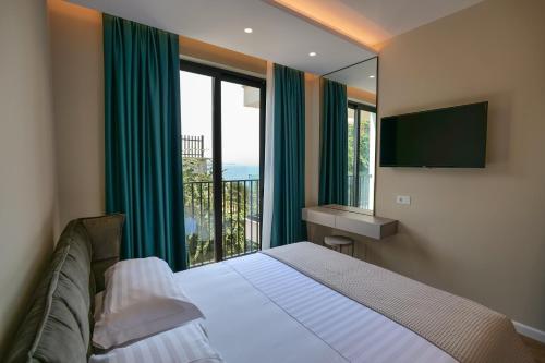 a bedroom with a bed and a large window at DAED Luxury Residence in Sarandë