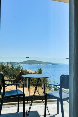 a table and chairs on a balcony with a view of the ocean at DAED Luxury Residence in Sarandë