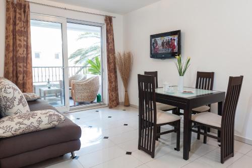 a living room with a table and chairs and a television at Apartmani Pašalić in Tučepi