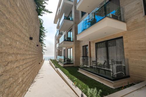 an apartment building with balconies and a sidewalk at DAED Luxury Residence in Sarandë