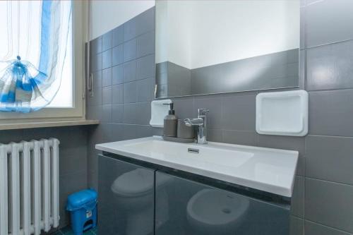 a bathroom with a white sink and a window at Casa Fiori [Centro città, Free parking] in Bra