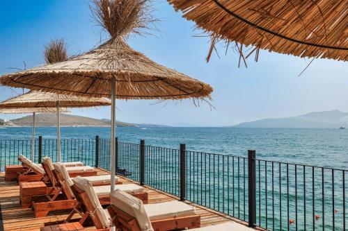a deck with chairs and umbrellas on the beach at DAED Luxury Residence in Sarandë