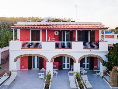 ein rotes und weißes Haus mit einer Terrasse in der Unterkunft Cala Dei Romani in Ventotene