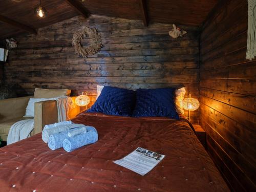 a bedroom with a bed with two blue towels on it at La Cabane de l’Explorateur in Cholet