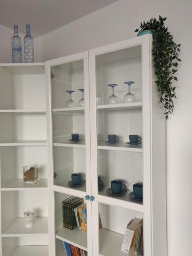 una estantería blanca con jarrones y libros azules en Płyta 129, en Gdynia