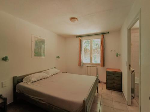 Schlafzimmer mit einem Bett und einem Fenster in der Unterkunft Villa 14 personnes en pleine campagne dans un parc naturel avec piscine privée in Villarzel-du-Razès