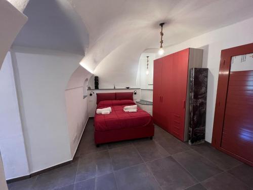 a red bed in a small room with a red door at A Cola in Rocchetta Nervina