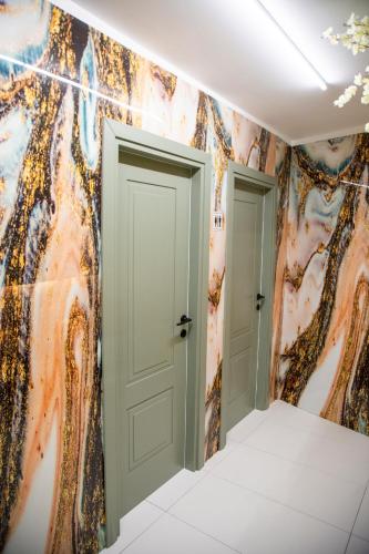 a hallway with two doors and a colorful wall at Andor Luxury Hotel & Duplex in Durrës