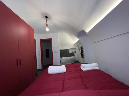 a room with two white pillows on a red carpet at A Cola in Rocchetta Nervina