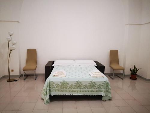a bedroom with a bed with two chairs in it at Casa vacanze Lola, Oria in Oria
