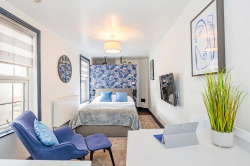 a bedroom with a bed and two blue chairs at North Laine Boutique in Brighton & Hove