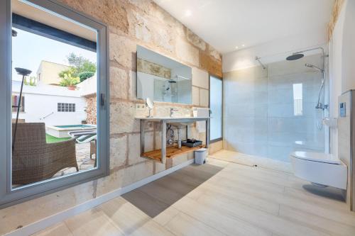 uma casa de banho com um chuveiro, um WC e um lavatório. em YupiHome Holiday Home S'Abellar em Santa Margalida