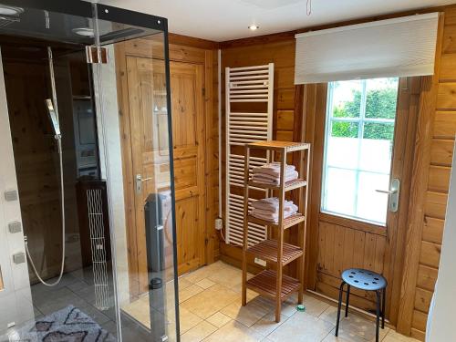 een badkamer met een douche en een glazen douchecabine bij Vrijstaande luxe Finse blokhut 2-6 of 2-8 pers in Kropswolde