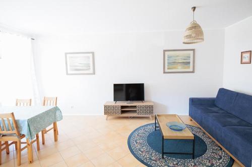 a living room with a blue couch and a table at APARTAMENTY BIAŁA MEWA - Na wydmie 8/9 in Ustka