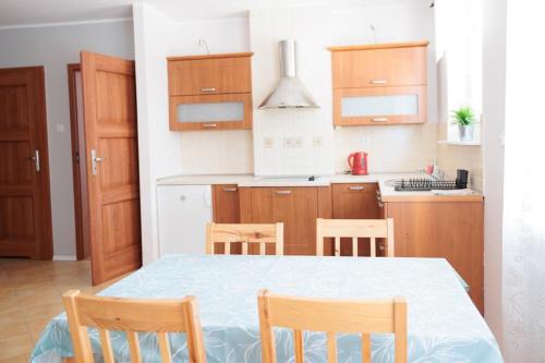 a kitchen with a table and chairs in a room at APARTAMENTY BIAŁA MEWA - Na wydmie 8/9 in Ustka