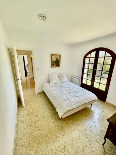 a bedroom with a bed and a window at Maison de Bernard in Le Beausset