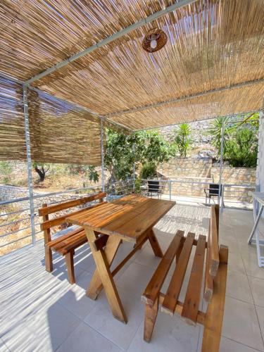 - une table de pique-nique en bois et des bancs sur une terrasse dans l'établissement Erika's House, à Lukovë