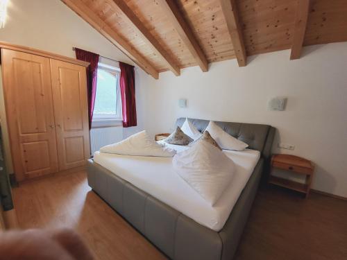 a bed with white pillows on it in a room at Adler Hotel-Pension in Fulpmes
