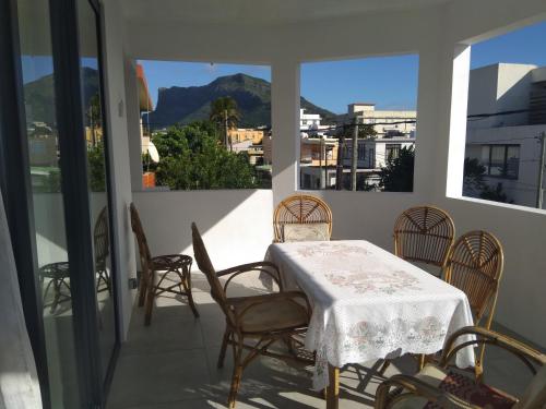 een eetkamer met een tafel en stoelen op een balkon bij Residence Lavande in Rose Hill