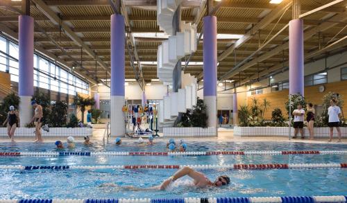 un groupe de personnes nageant dans une piscine dans l'établissement Studio « Le petit Prat », à Colomiers