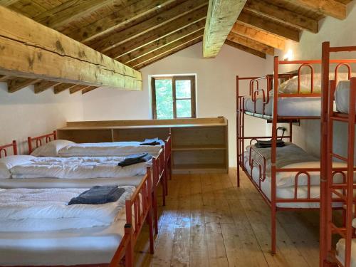 a room with four bunk beds in a building at Baita Misonet in Comano Terme