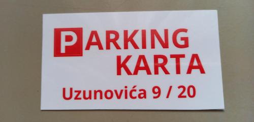 a sign hanging on a wall with the words parking karma at Venus Apartman in Brčko