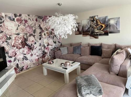 uma sala de estar com um sofá e uma parede de flores em Résidence Birdie em Jalhay