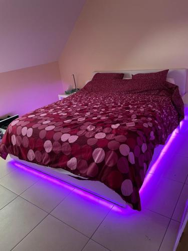 um quarto com uma cama com uma iluminação LED roxa em Résidence Birdie em Jalhay