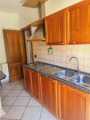 a kitchen with wooden cabinets and a sink at Mosè House in Formia