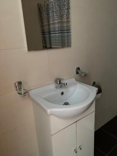 a white sink in a bathroom with a mirror at Sea View Studios Bali Harbour Beach in Balíon