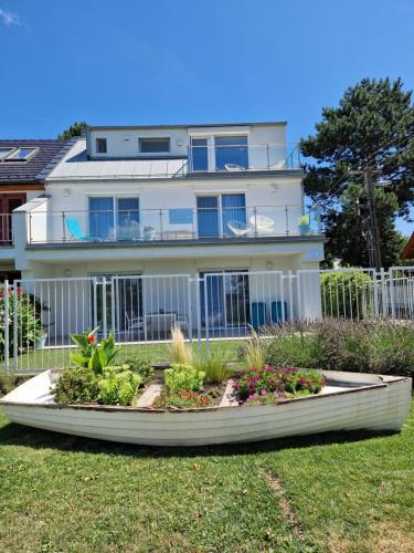 a large white house with a garden in front of it at Panoramic apartments in Balatonvilágos