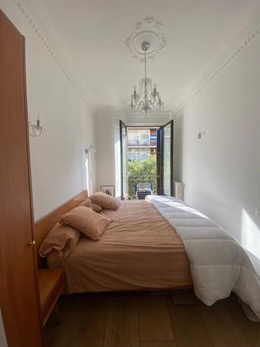ein Schlafzimmer mit einem großen Bett mit einem Kronleuchter in der Unterkunft Apartamento eixample Barcelona in Barcelona