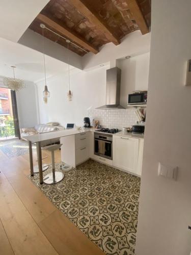 eine Küche mit weißen Schränken und einem Tisch in der Unterkunft Apartamento eixample Barcelona in Barcelona