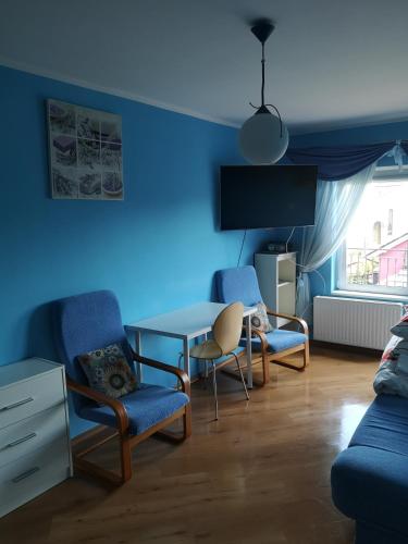 a blue living room with chairs and a table at Pokój Gościnny Gdańska 21 J in Świnoujście