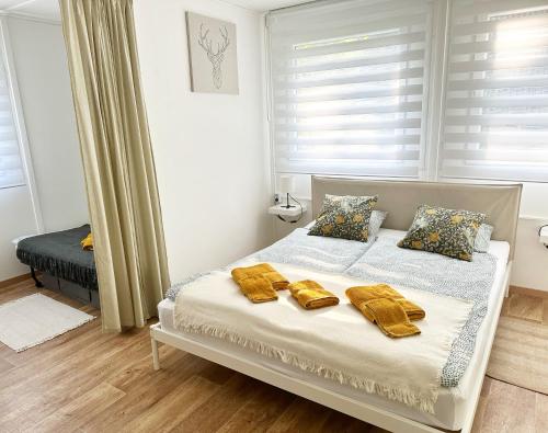 Un dormitorio con una cama con toallas amarillas. en Nordin Apartman, en Hódmezővásárhely