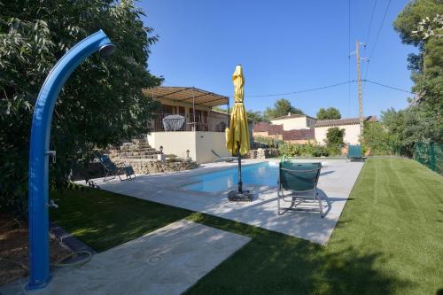 une piscine avec une chaise et un parasol jaune dans l'établissement Villa La Couaste, à Lorgues