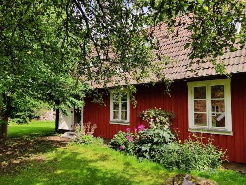 una casa roja con techo rojo en Stuga i natursköna mittskåne en Höör