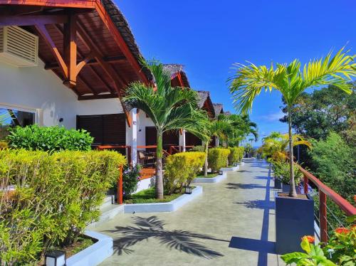a pathway with palm trees and a building at Andriana Resort & Spa in Nosy Be
