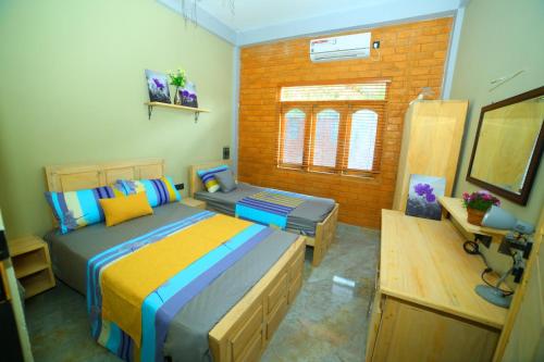 a bedroom with two beds and a bench in it at Ammu villa in Point Pedro