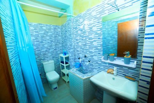 bagno blu con lavandino e servizi igienici di Ammu villa a Point Pedro