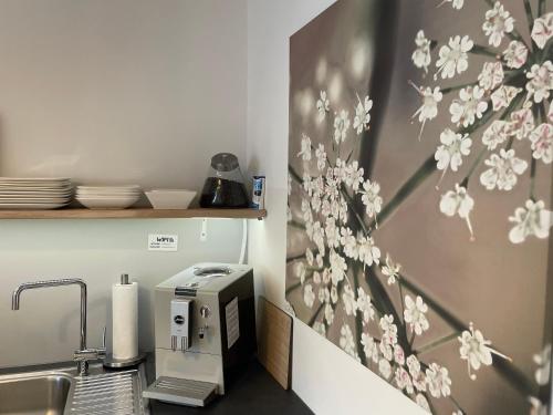 a kitchen with a sink with a toaster and flowers on the wall at Weberhof - Münster 5 in Münster